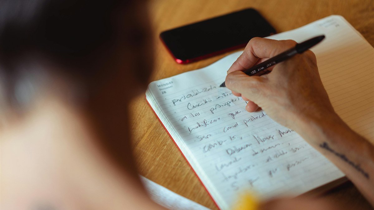 person journaling beside a phone during a digital clarity reset