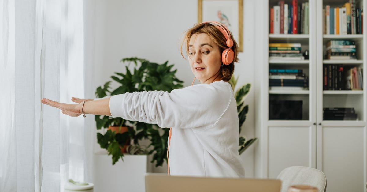 A person stretching beside a home office desk